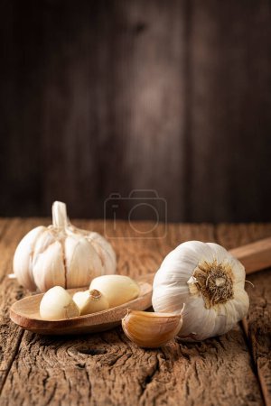 Foto de Bulbo de ajo y dientes de ajo en la mesa de madera
. - Imagen libre de derechos