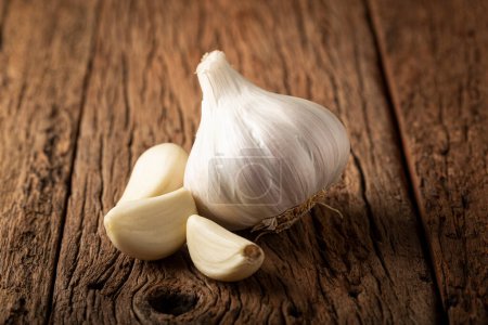 Photo for Garlic bulb and garlic cloves on the wooden table. - Royalty Free Image