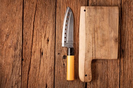 Cuchillo de chef y tabla de cortar en mesa de madera rústica.