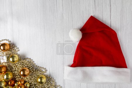 Téléchargez les photos : Chapeau de Père Noël avec décorations de Noël sur table en bois. - en image libre de droit