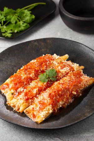 Pancakes stuffed with minced meat and topped with tomato sauce and grated cheese.