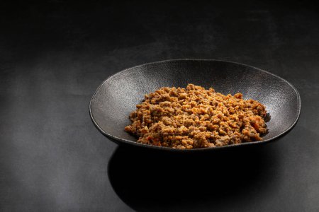 Photo for Ground beef in dark plate on the table. - Royalty Free Image