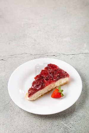 Photo for Strawberry glazed cheesecake on white dinnerware on the table. - Royalty Free Image