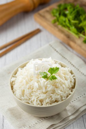 Bowl with cooked rice on the table.