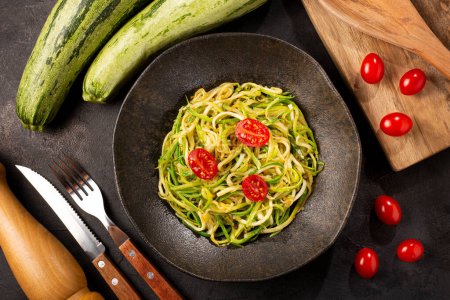 Foto de Espaguetis de calabacín con tomates en ajo y aceite. - Imagen libre de derechos