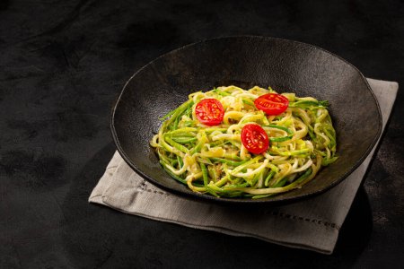 Photo for Zucchini spaghetti with tomatoes in garlic and oil. - Royalty Free Image