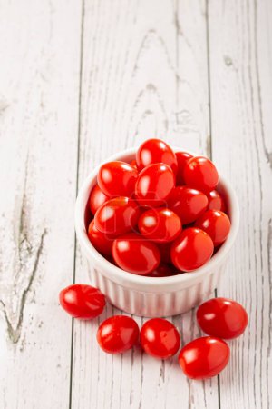 Foto de Tomates de uva frescos en un tazón sobre la mesa. - Imagen libre de derechos
