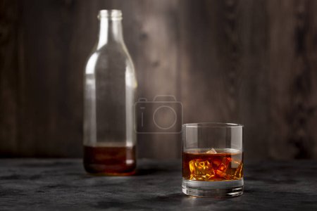 Photo for Whiskey bottle and whiskey glass with ice. - Royalty Free Image