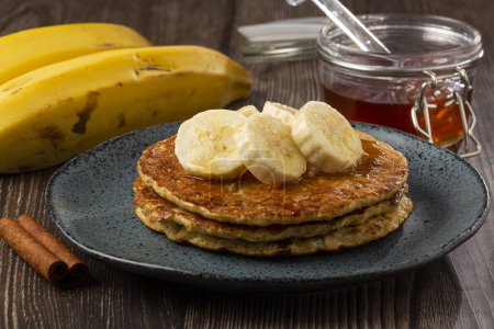 Photo for Banana and oat pancakes topped with sliced bananas and honey. - Royalty Free Image