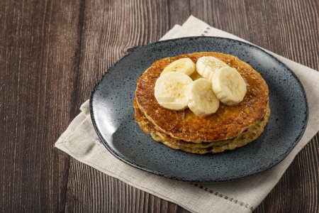 Banana and oat pancakes topped with sliced bananas and honey.