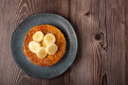 Photo for Banana and oat pancakes topped with sliced bananas and honey. - Royalty Free Image