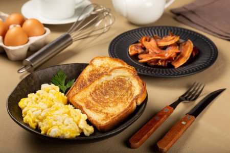 Téléchargez les photos : Petit déjeuner. Œuf brouillé avec pain grillé et bacon. - en image libre de droit