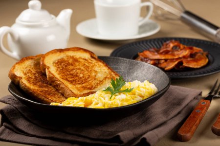 Téléchargez les photos : Petit déjeuner. Œuf brouillé avec pain grillé et bacon. - en image libre de droit