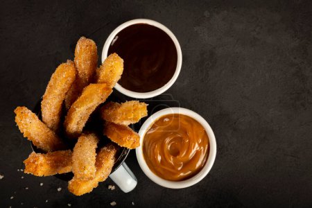 Photo for Sugary churros with dulce de leche. - Royalty Free Image