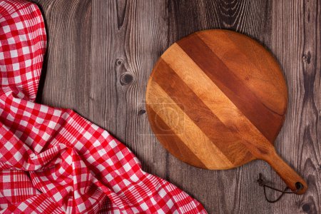 Planche à pizza vide sur table rustique en bois. Image vue du dessus.