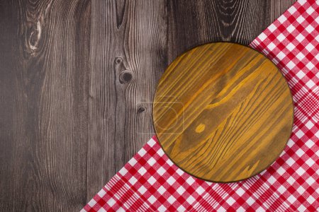 Planche à pizza vide sur table rustique en bois. Image vue du dessus.