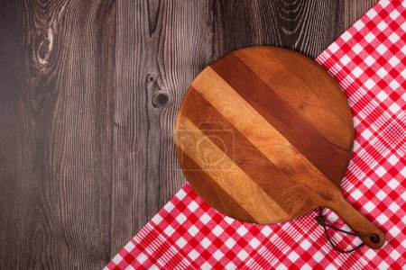 Empty pizza board on rustic wooden table. Top view image.