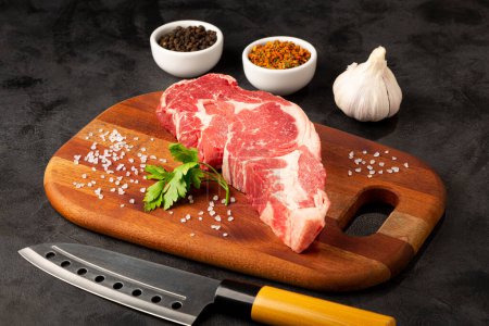 Photo for Raw ancho meat ready to roast on a wooden cutting board. - Royalty Free Image