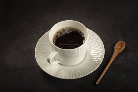 Leckere Profiterolen mit Kaffee auf dem Tisch.