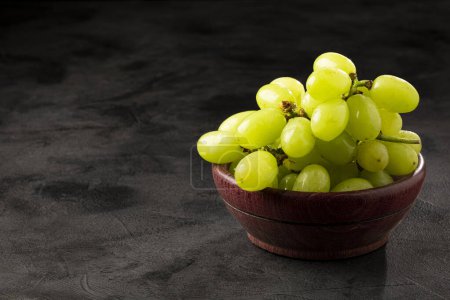 Téléchargez les photos : Raisins verts frais dans un bol en bois. - en image libre de droit