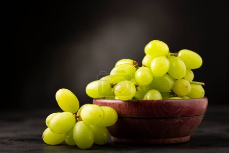 Photo for Fresh green grapes in wooden bowl. - Royalty Free Image