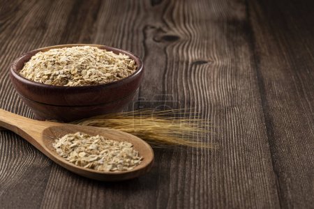Photo for Oat flakes in wooden bowl. - Royalty Free Image