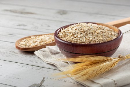Oat flakes in wooden bowl.