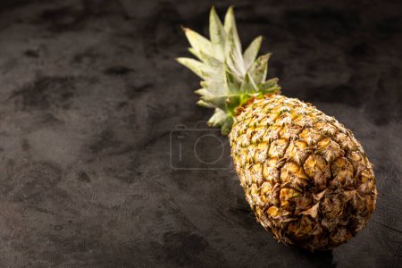 Téléchargez les photos : Ananas entier sur fond sombre. - en image libre de droit
