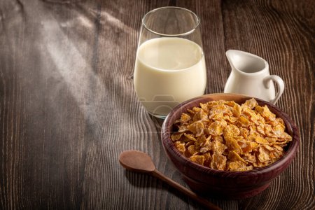 Foto de Copos de maíz en tazón y vaso de leche en la mesa. - Imagen libre de derechos