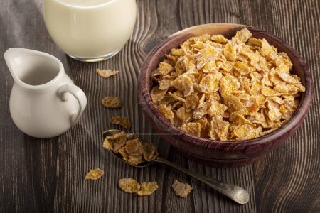 Photo for Corn flakes in bowl and glass of milk on table. - Royalty Free Image