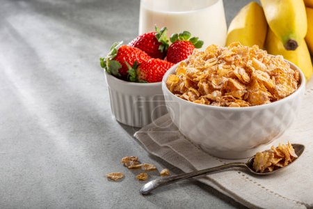 Photo for Corn flakes in the bowl with berries and milk on the table. - Royalty Free Image