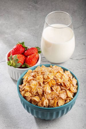 Photo for Corn flakes in the bowl with berries and milk on the table. - Royalty Free Image