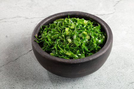 Photo for Bowl with chopped green cabbage sauteed in olive oil and garlic. - Royalty Free Image