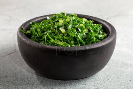 Bowl with chopped green cabbage sauteed in olive oil and garlic.