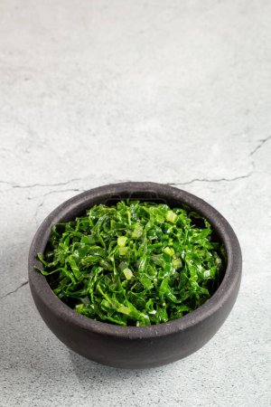 Photo for Bowl with chopped green cabbage sauteed in olive oil and garlic. - Royalty Free Image
