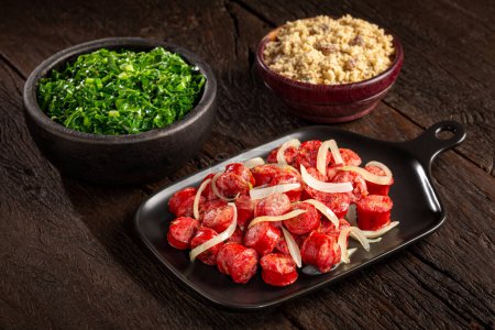 Téléchargez les photos : Saucisse tranchée avec oignon, chou vert et farofa. - en image libre de droit