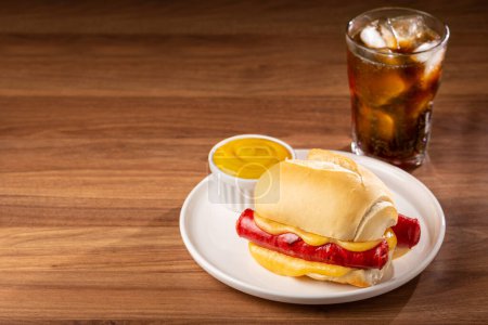 Cheese and sausage sandwich with soda glass.