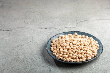 Photo for Raw chickpeas in the plate on the table. - Royalty Free Image