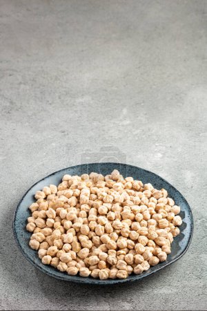 Raw chickpeas in the plate on the table.