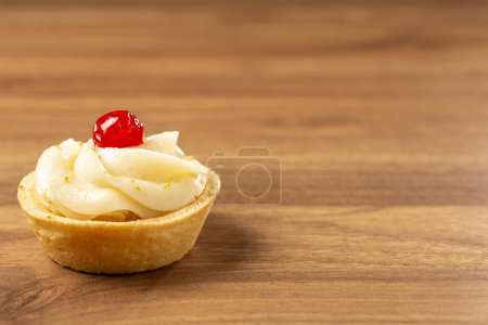 Lemon tartlets decorated with cherry.