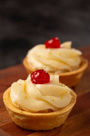 Téléchargez les photos : Tartelettes au citron décorées de cerises. - en image libre de droit