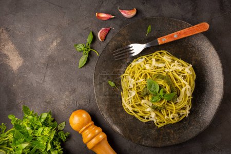 Foto de Espaguetis de pasta con salsa de pesto y hoja de albahaca. - Imagen libre de derechos