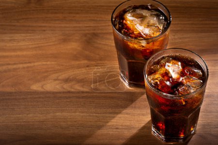 Téléchargez les photos : Verres à coke avec glaçons sur table en bois. - en image libre de droit