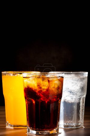 Photo for Glasses of soda flavors orange, lemon and coke. - Royalty Free Image