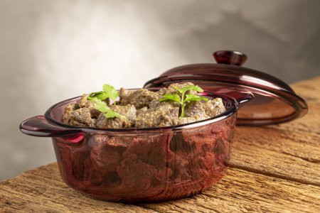 Foto de Carne cocida en la sartén sobre la mesa de madera. Estofado de carne. - Imagen libre de derechos
