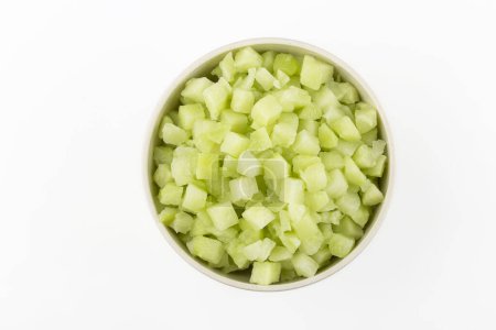 Chayote cubes in bowl isolated on white background.