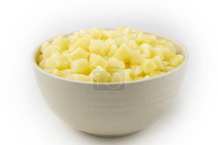 Téléchargez les photos : Cubes de pommes de terre crues dans un bol isolé sur fond blanc. - en image libre de droit
