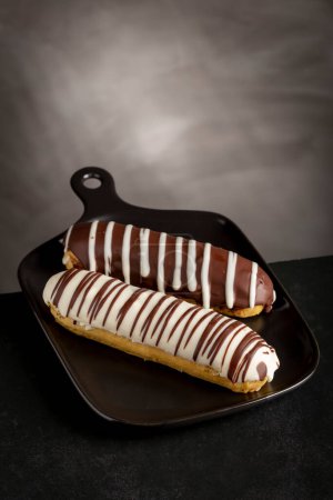 Photo for Eclair. Tasty chocolate eclair on the table. - Royalty Free Image