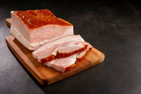 Trancher du bacon cru sur la table
