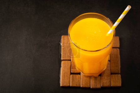 Foto de Zumo de mango en taza de vidrio sobre la mesa. Batido de mango. - Imagen libre de derechos